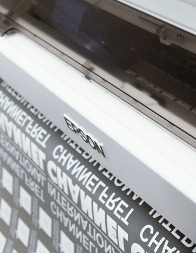 Imprimante Epson en train d’imprimer des motifs sur un film DTF qui sort de la machine.